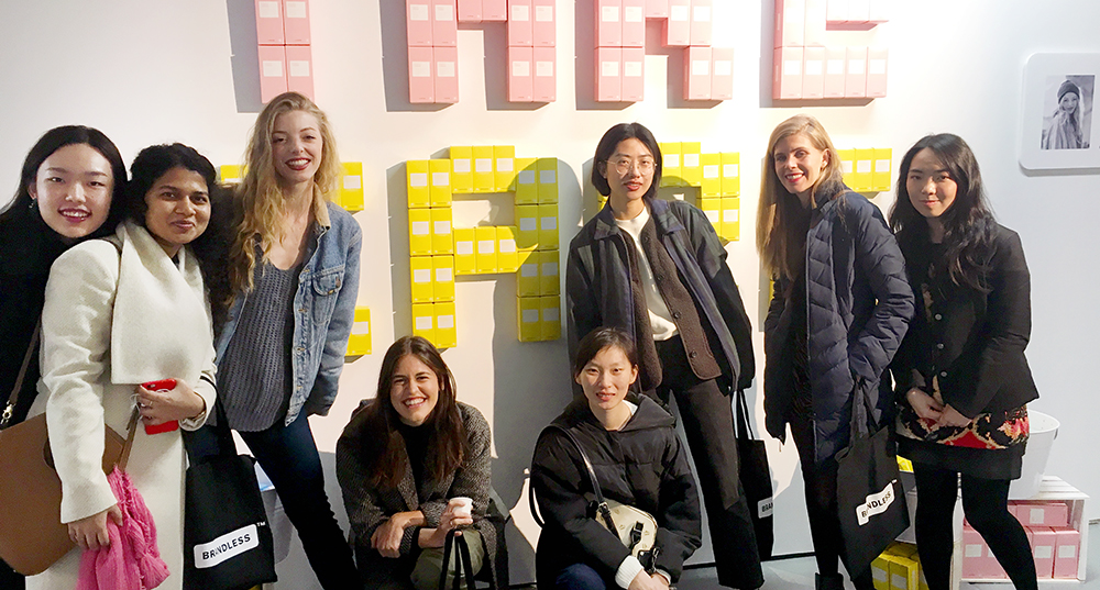 group photo of students in front of the Take Care sign on the wall