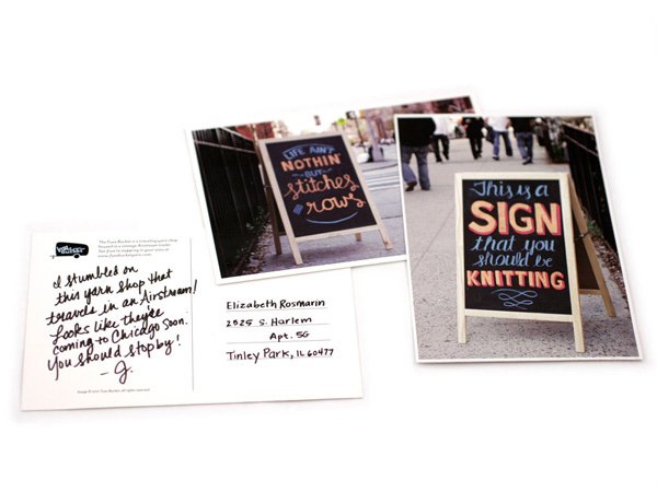 postcard with restaurant signs on the sidewalk, and one of them has a text on its back