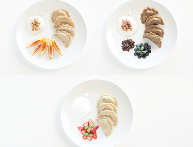three white plates with dumplings and fruit garnishes