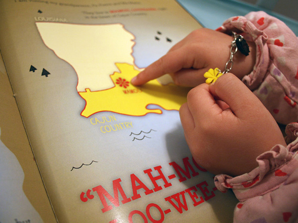 a child pointing whit their finger to a flower point on a map