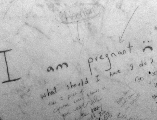 a table surface with small text written on it and the biggest message is I am pregnant :(