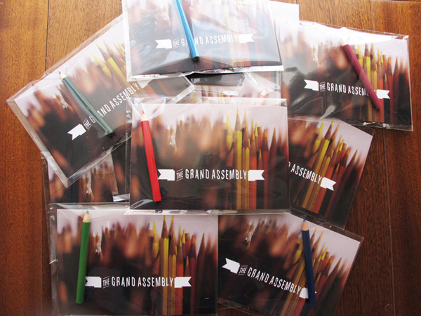 a pile of postcards, and the package contains colored pencilS