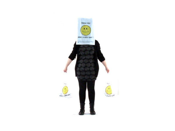 e person with a bag in each hand and a paper bag with a smiley face covering their head