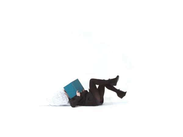 image of a woman lying on her back with a book covering her face