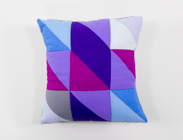 a small cushion with an angular blue and purple pattern