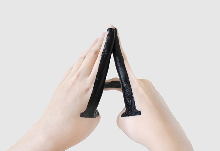 the hands of a person forming the A letter-shaped, and the letter is painted in black