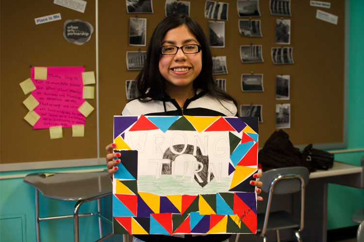 portrait of a girl holding a drawing with geometric shapes and a two-words text
