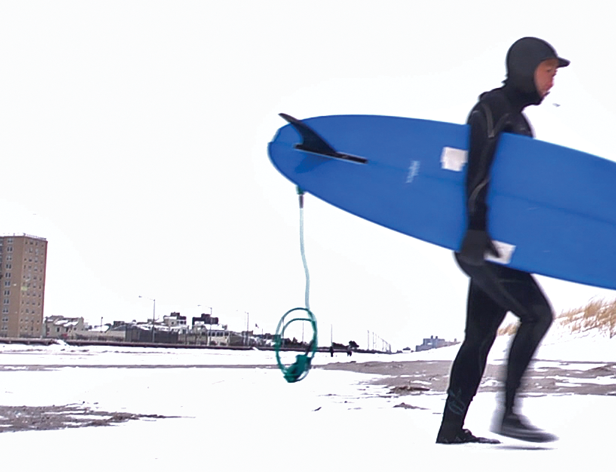 a person with a blue surfing board getting out of the water