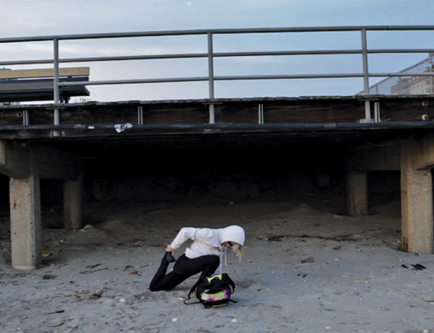 photo of a person crouching near a bridge