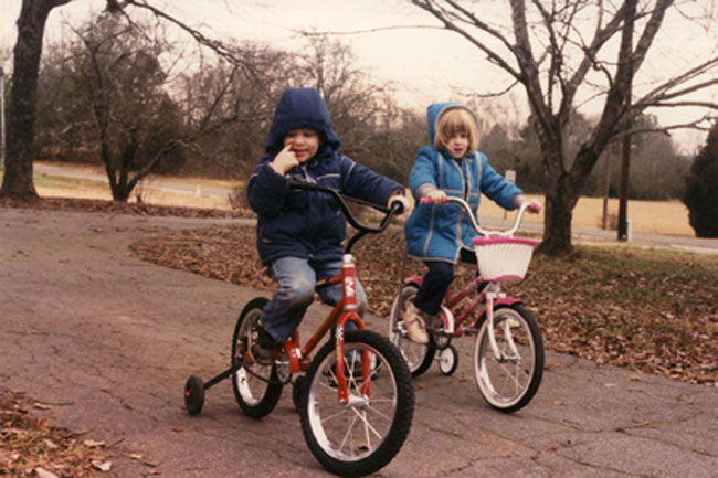 photo depicting two kids riding bikes in the park