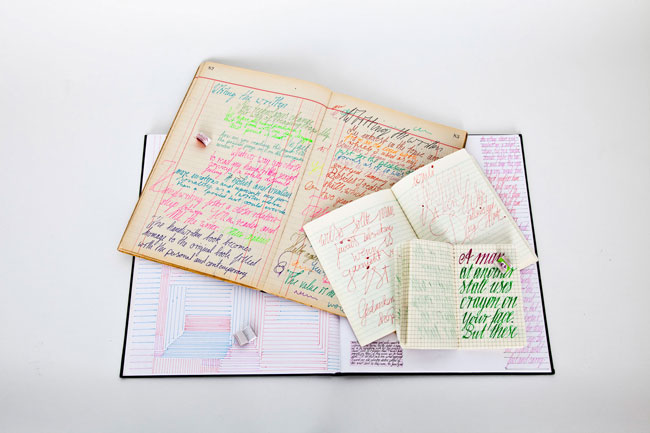 Opened notebooks on top of each other depicting different colored texts and typography