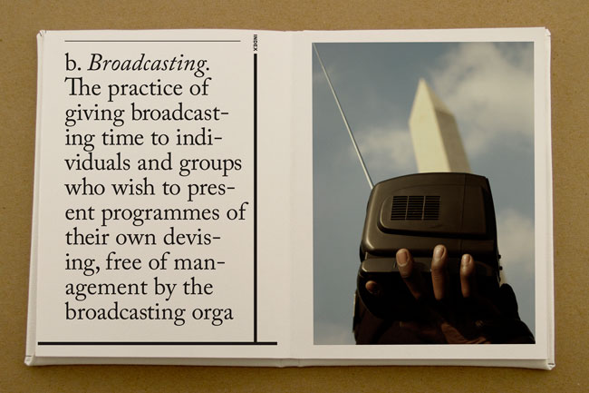 A book opened and on the left page is the Broadcasting definition: The practice of giving broadcasting time to individuals and groups who wish the present programmes of their devising, free of management by the broadcasting orga. And on the right page is a photo of a hand holding a portable radio