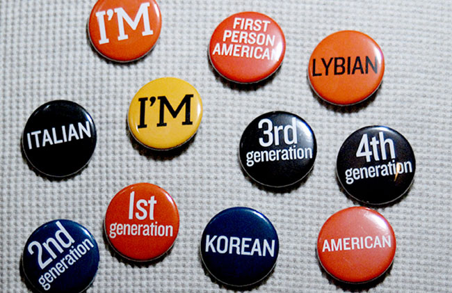 red, black, and yellow badges with messages and names of countries on them