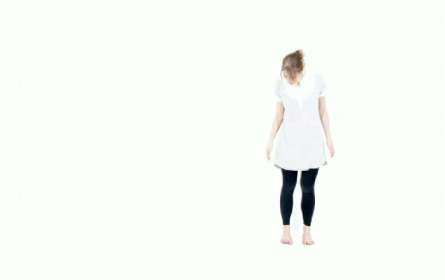 woman wearing a white shirt and black pants in a white room