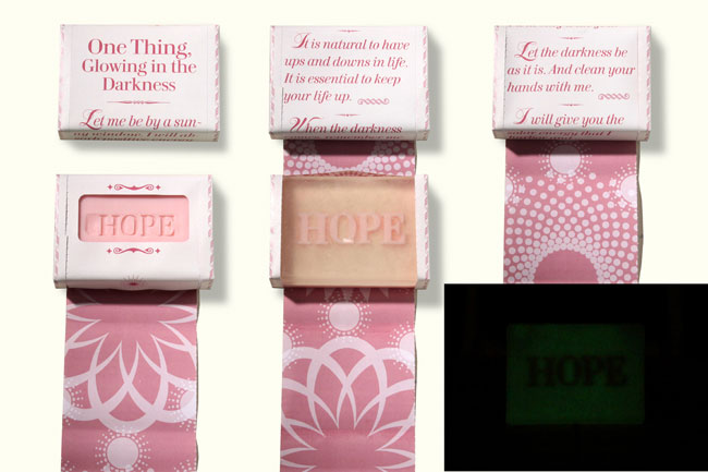 soap bars packed in a white paper with pink text, and the last of the 3 bars are glowing in the dark with the word hope written on them