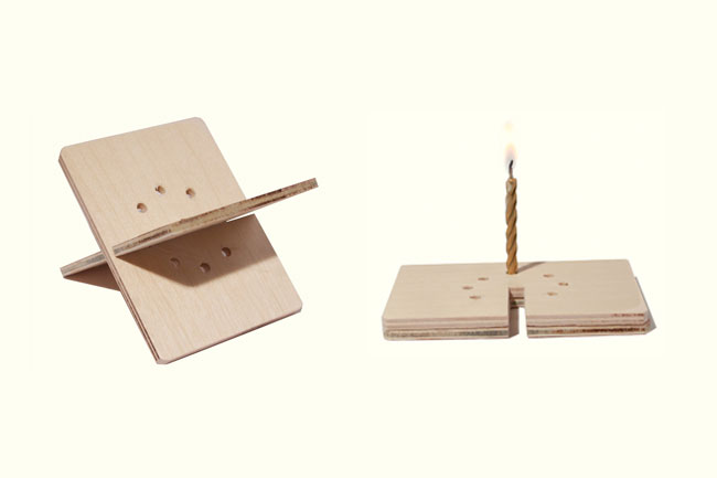 a wood structure in X, and next to it is a piece of the structure acting as a stand for a candle