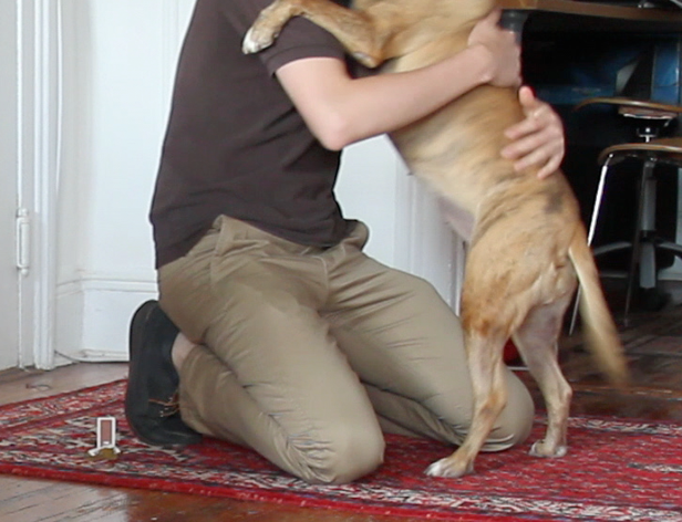 a still with a man hugging a dog