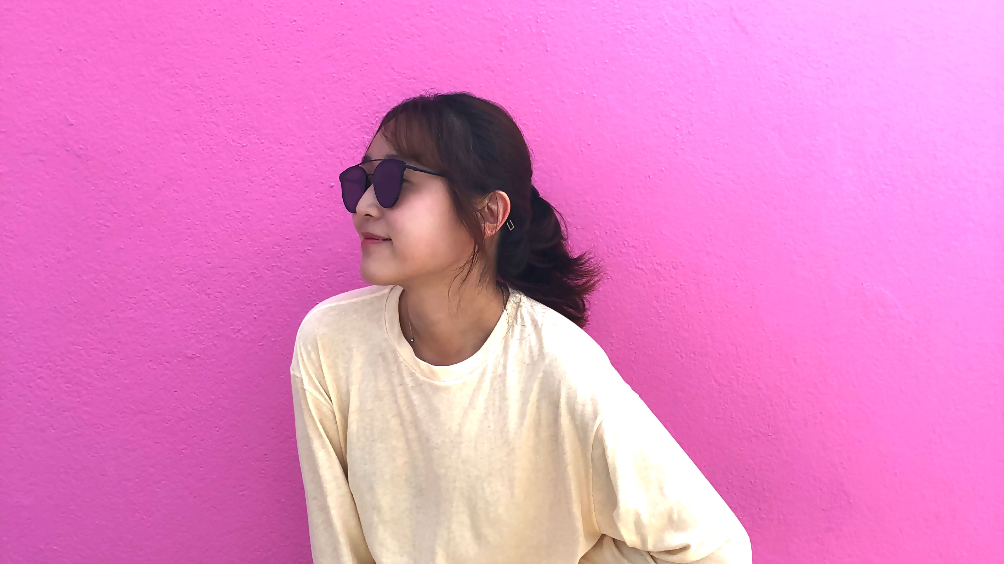picture of Mingu Lee posing in beige long sleeve and glasses in front on pink wall