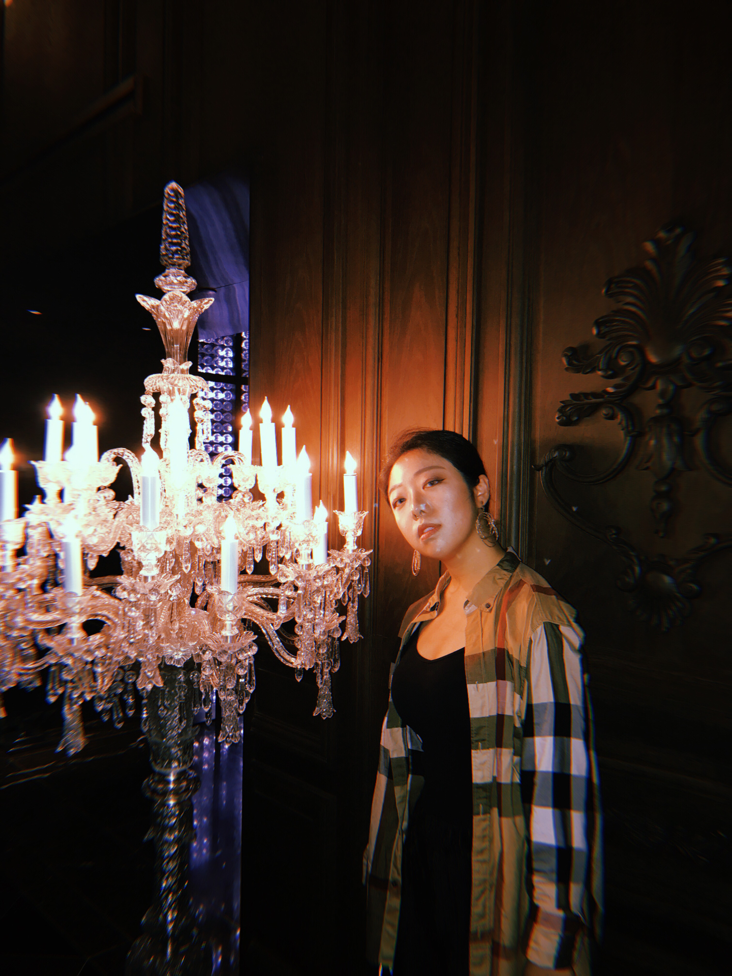 Xi Lu posing by a chandelier