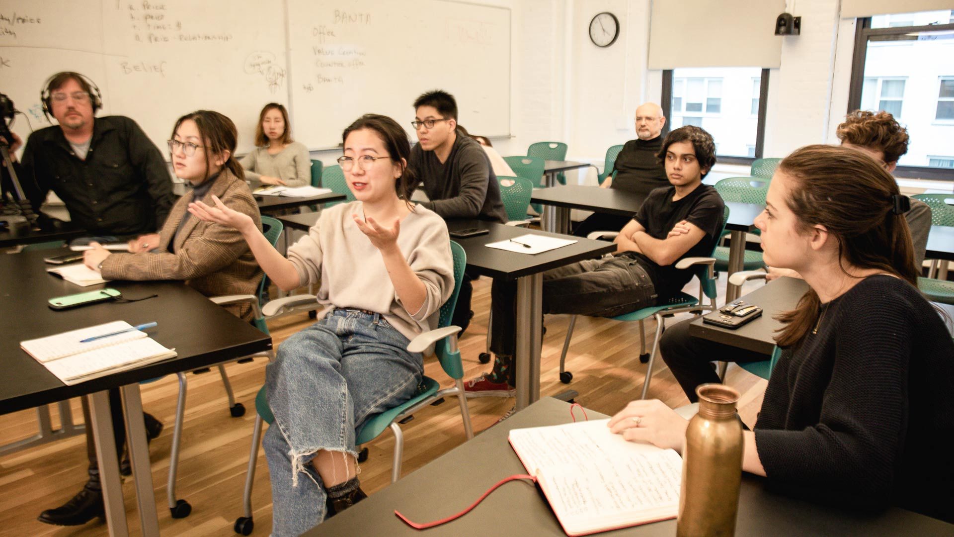 student asking a question with others listening