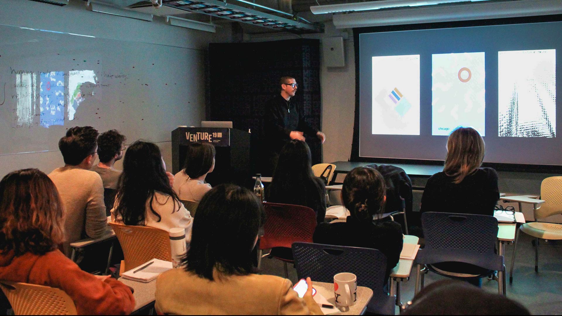 Jesse Reed at SVA MFA Design giving a lecture in a darkened classroom