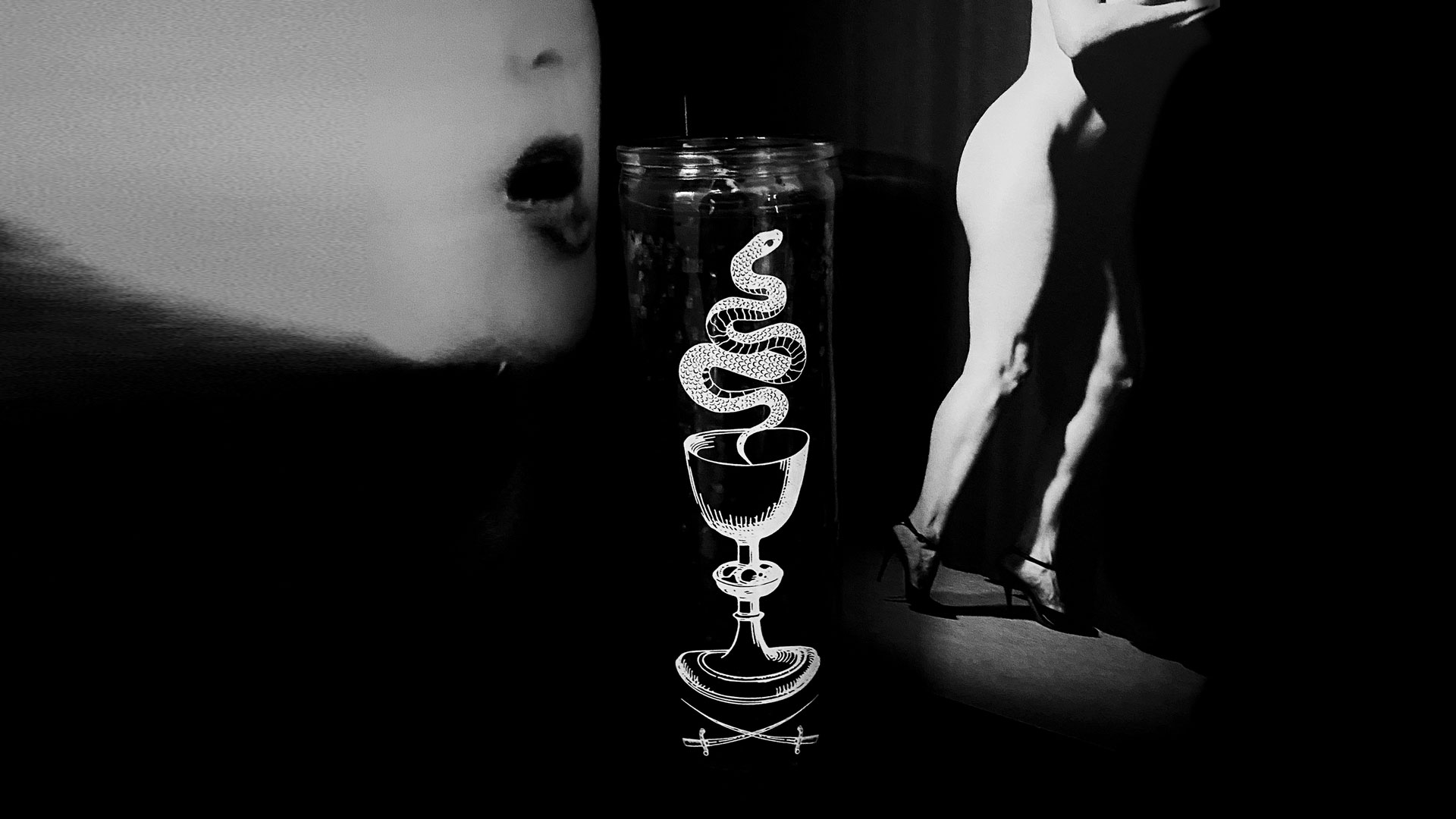 black candle with snake design with face and nude figure