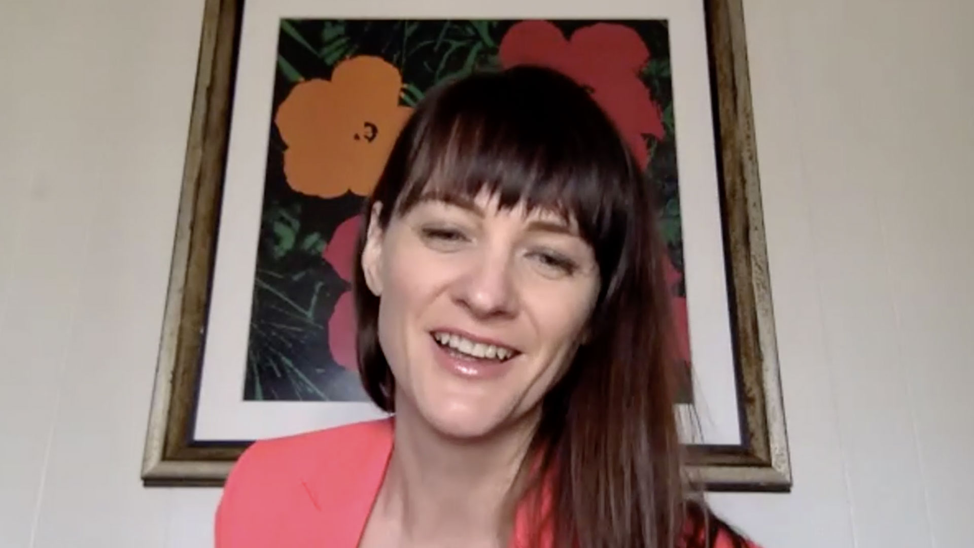 portrait of Suzanne Mckenzie in pink top and andy warhol flowers print in background