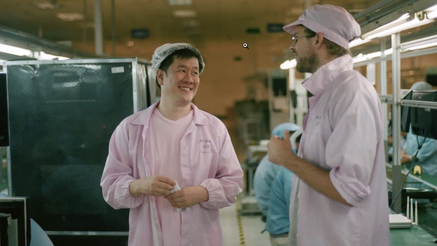 hugh francis and another man dressed in pink uniforms in phone factory