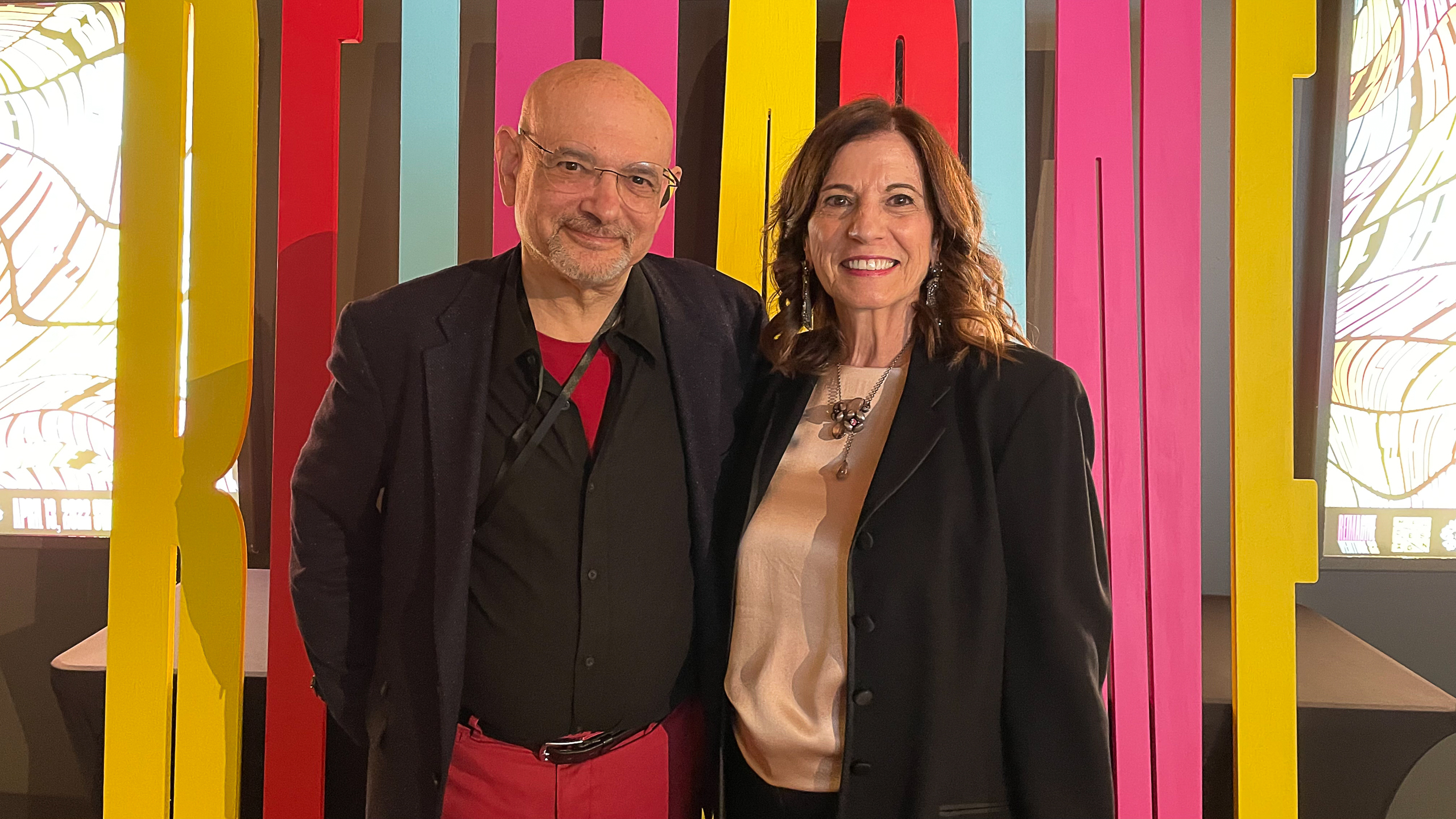 Steven Heller and Lita Talarico in front of sign