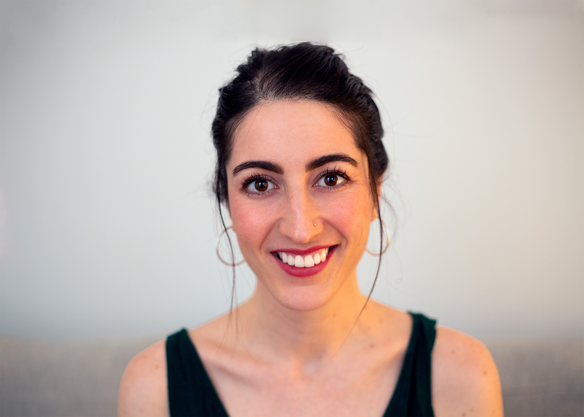 A photo of a smiling woman wearing a black dress.