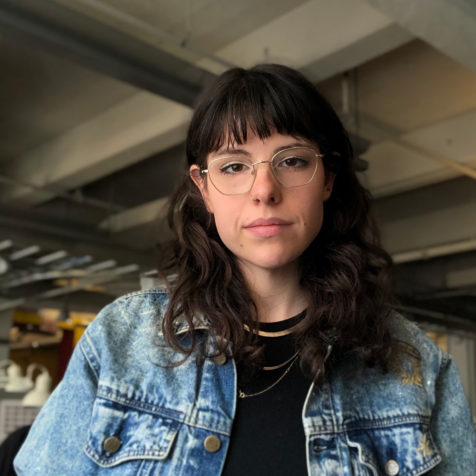 A photo of a woman wearing glasses and a jean jacket.