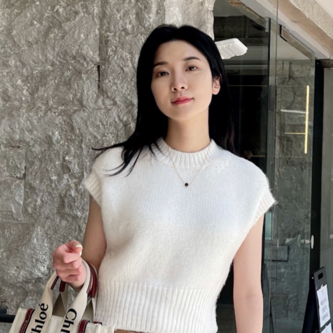 asian woman with white shirt and brown pants holding a bag