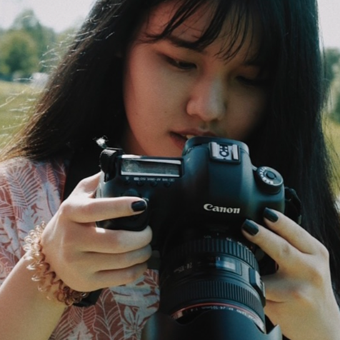 asian woman holding camera in the nature