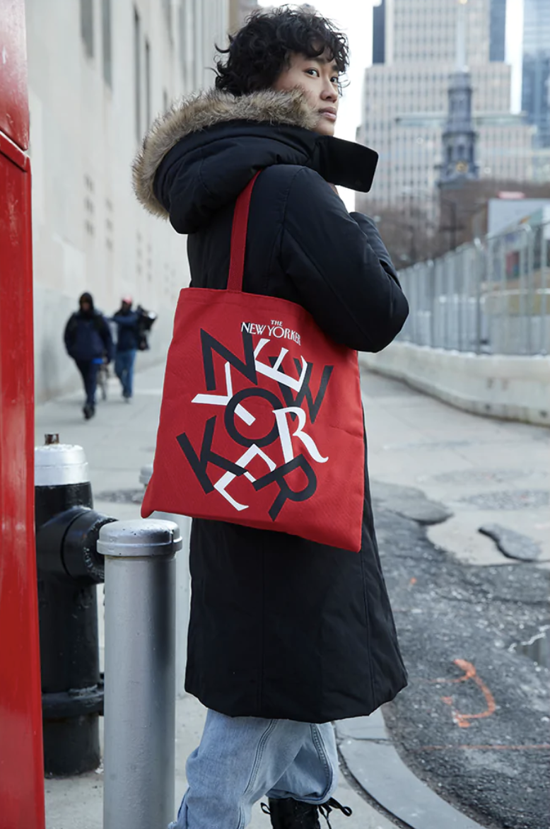 woman holding red totebag in the street
