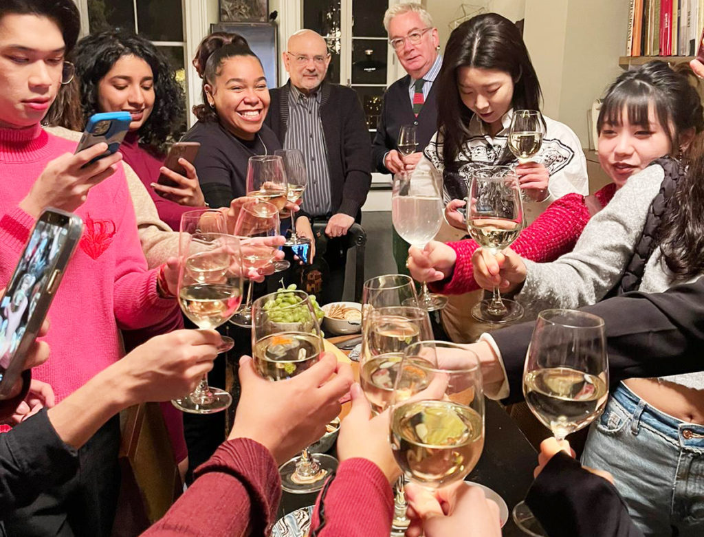 dinner party with people raising glasses in cheer