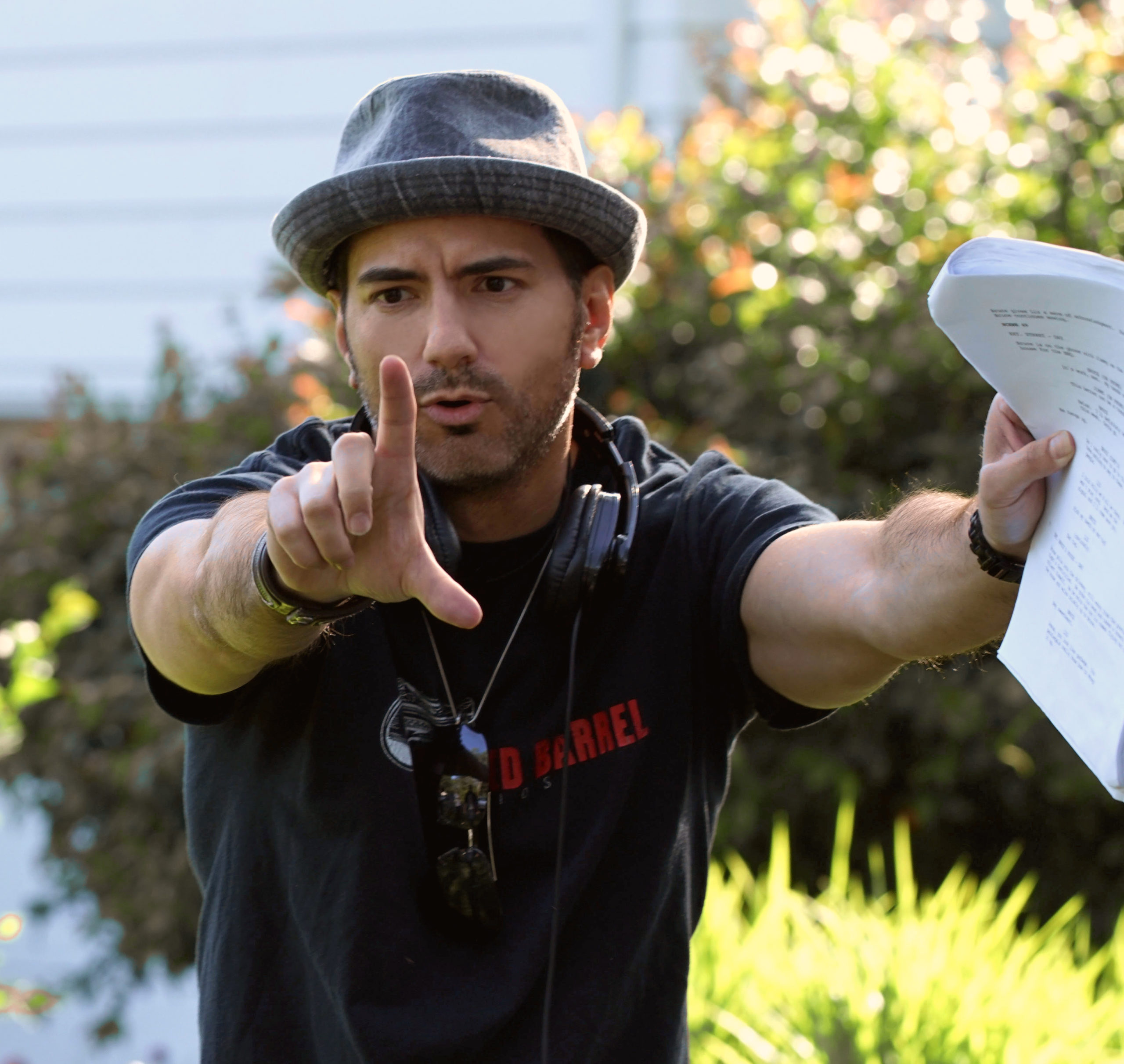 men with hat in garden directing film