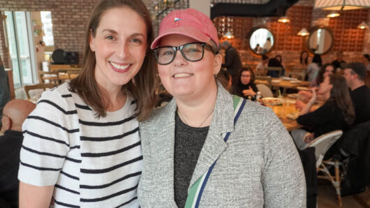 two women facing the camera inside a restaruant