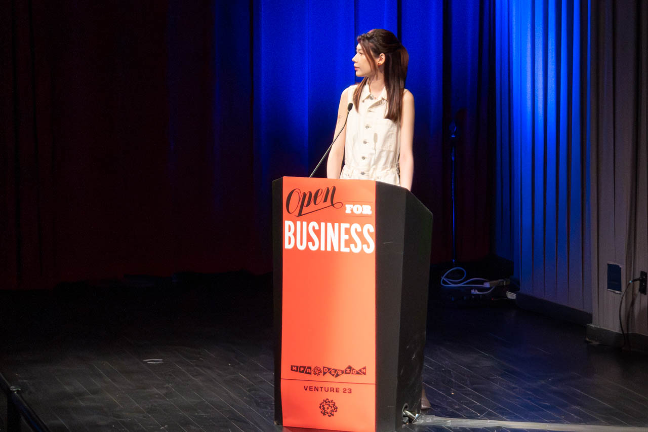 woman standing at a podium delivering a presentation