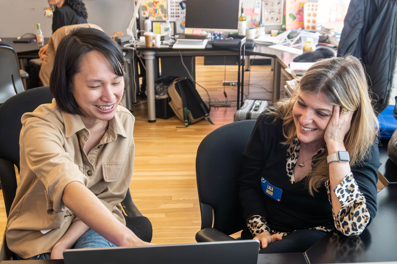 two people talking next to a computer