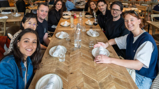 Group of people at a restaurant table looking at the camera for the photo