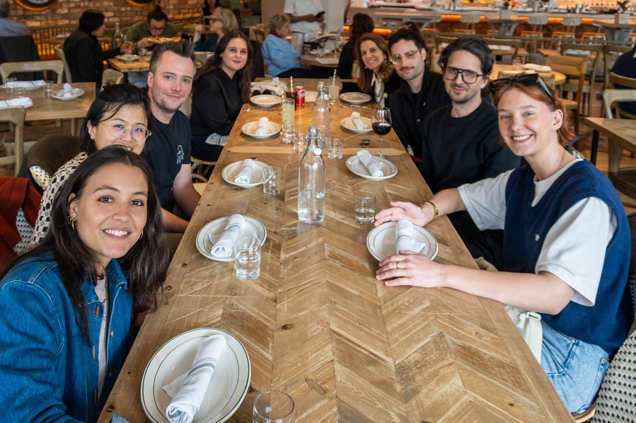 Group of people at a restaurant table looking at the camera for the photo