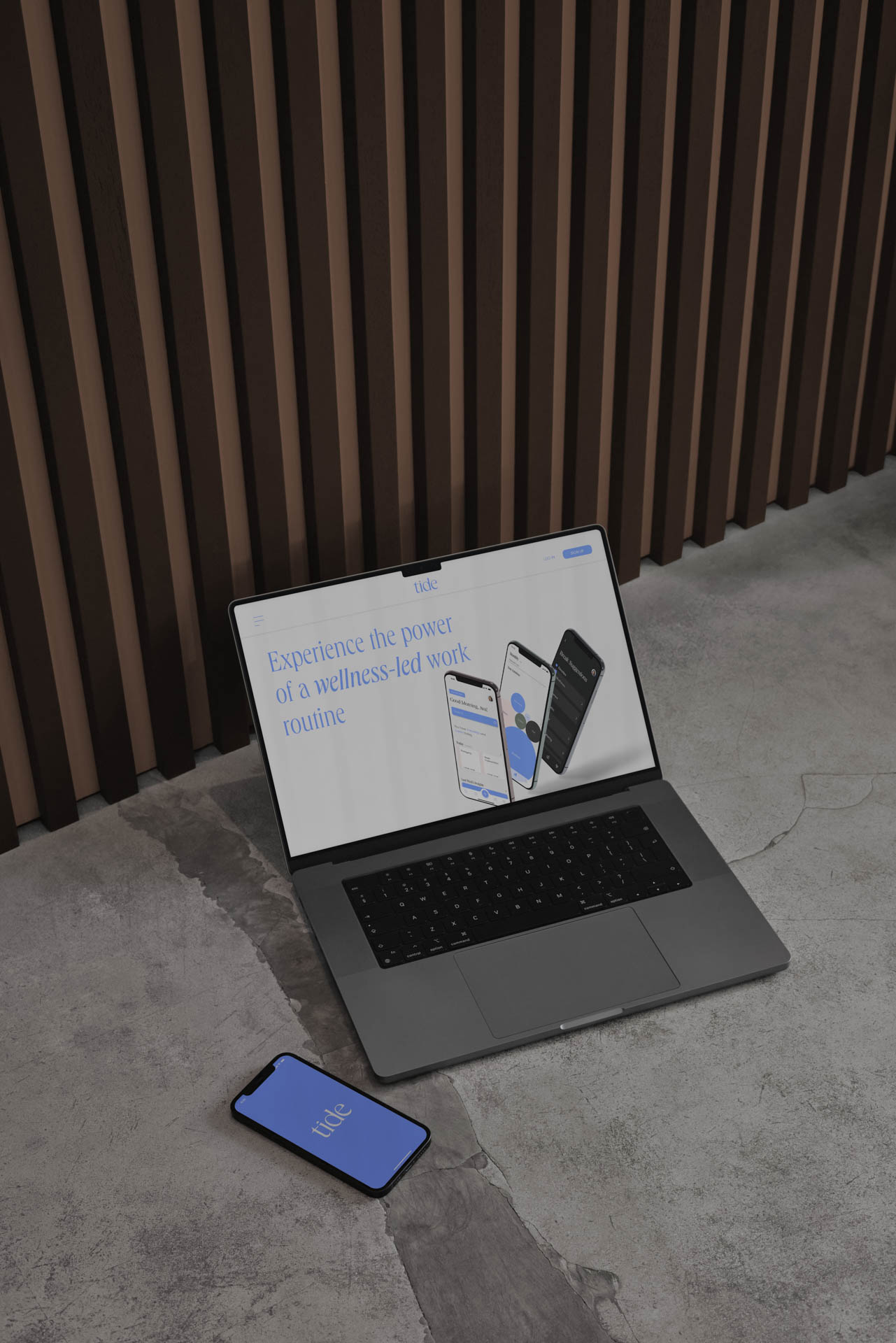 a laptop and an iphone on a cement floor  showing the Tide app