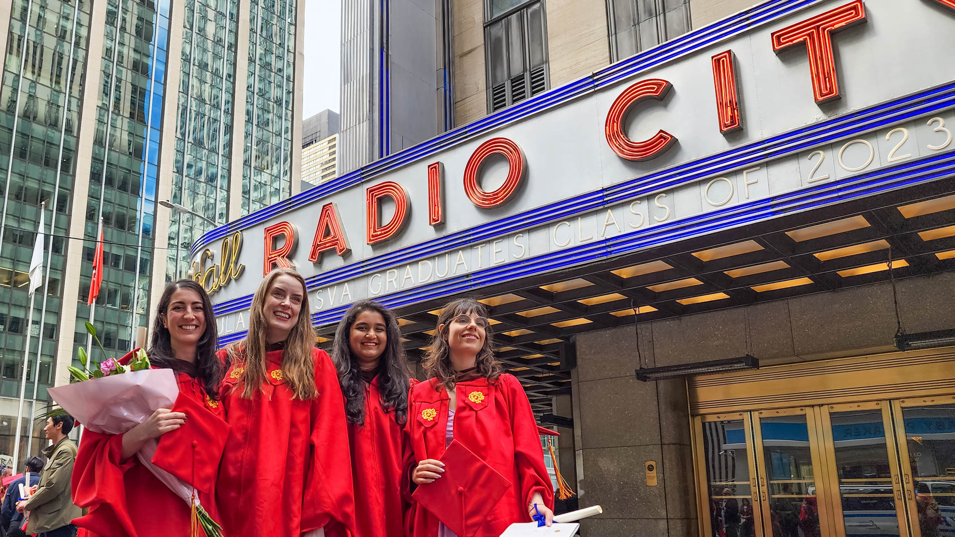 four students in their cap and gown in front of Radio City Music Hall