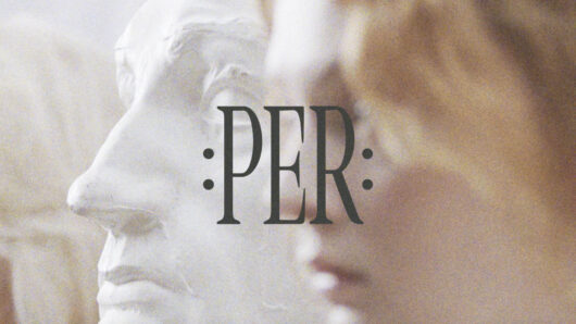 the word PER with a sculpture in the background
