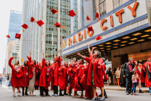 Students throwing up their caps outside of Radio City Music Hall