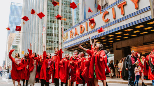 Students throwing up their caps outside of Radio City Music Hall