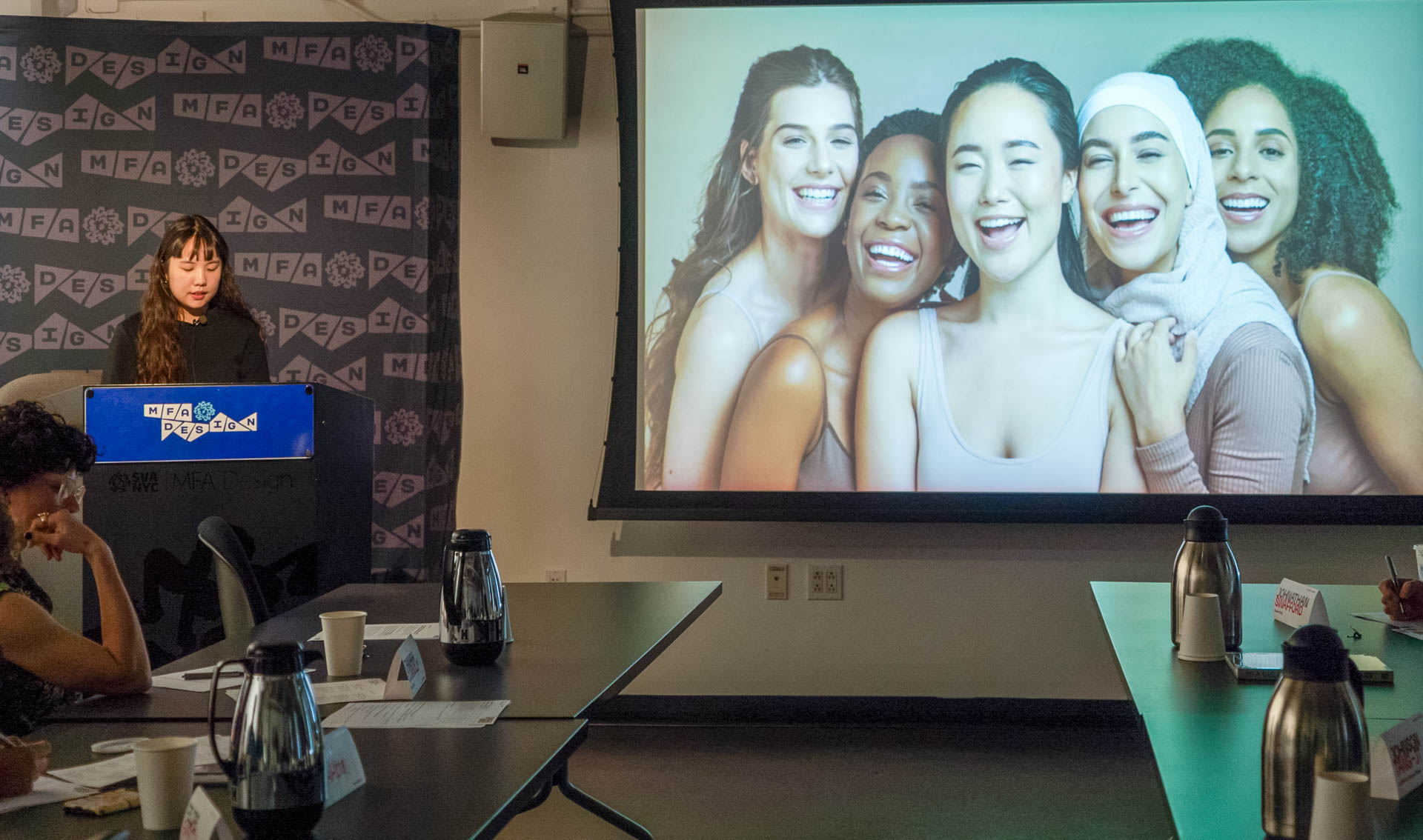 Student standing at the podium presenting Thesis work slideshow