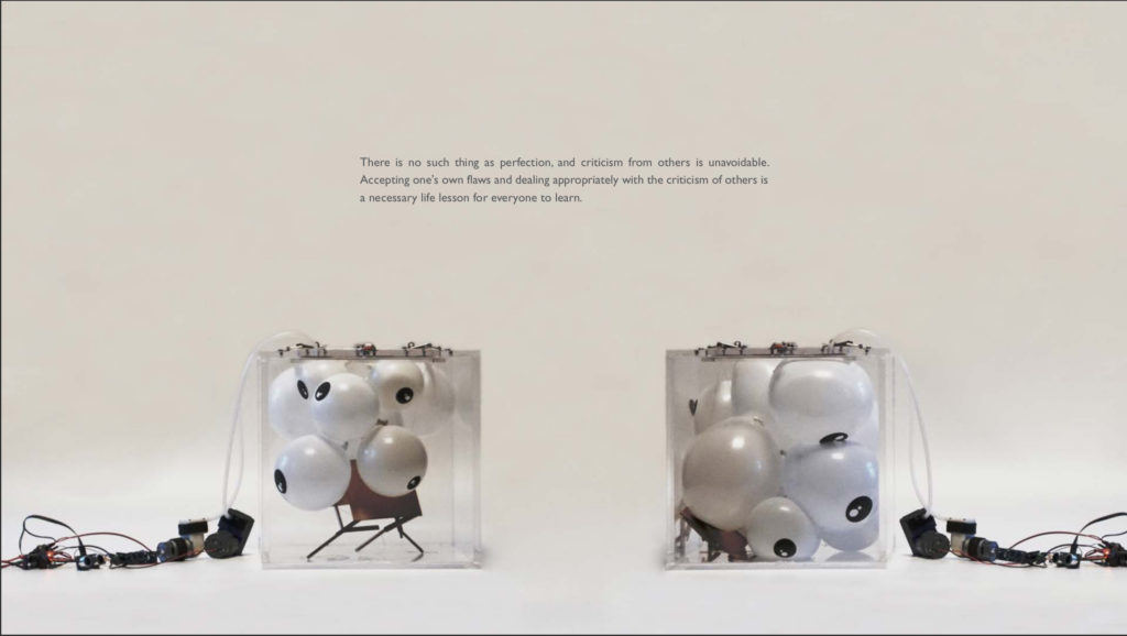 art piece showing two clear cubes with fake eyeballs inside and electronic cables attached to the cubes