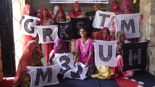 a group of people holding up Indian handcrafted lettering