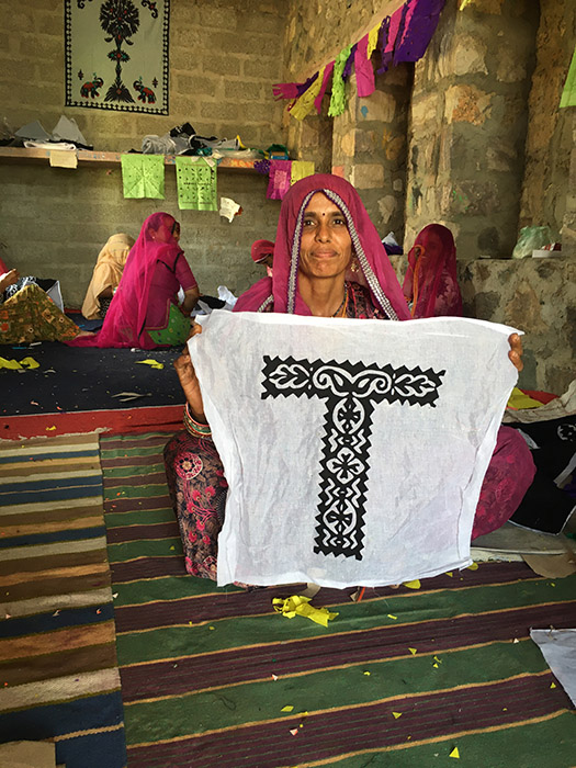 a woman holding up Indian handcrafted lettering